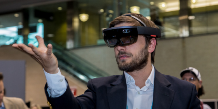 A man holds virtual object while wearing augmented reality glasses.